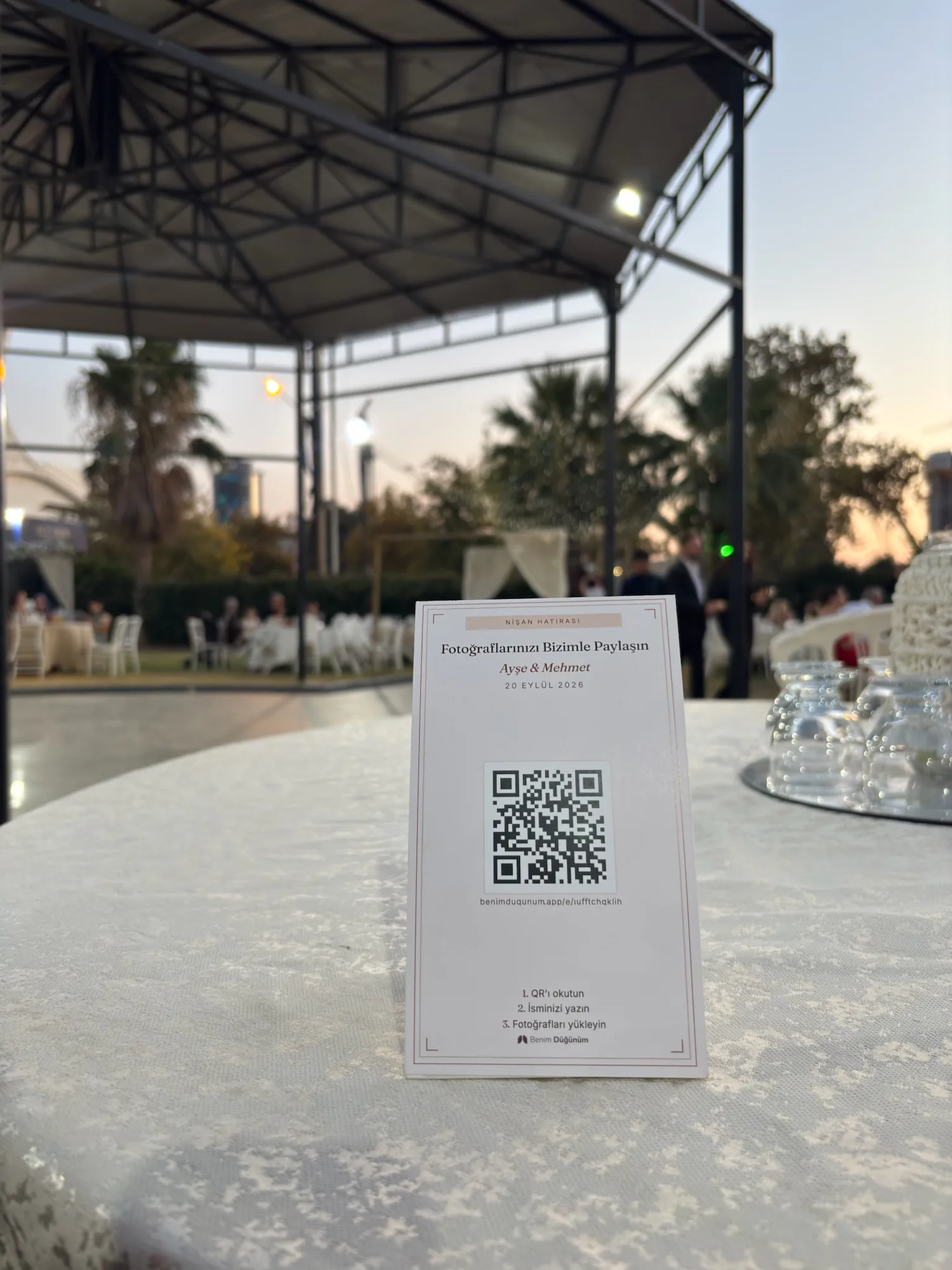 Düğün salonunda masanın üzerinde duran gerçek QR fotoğraf paylaşım kartı