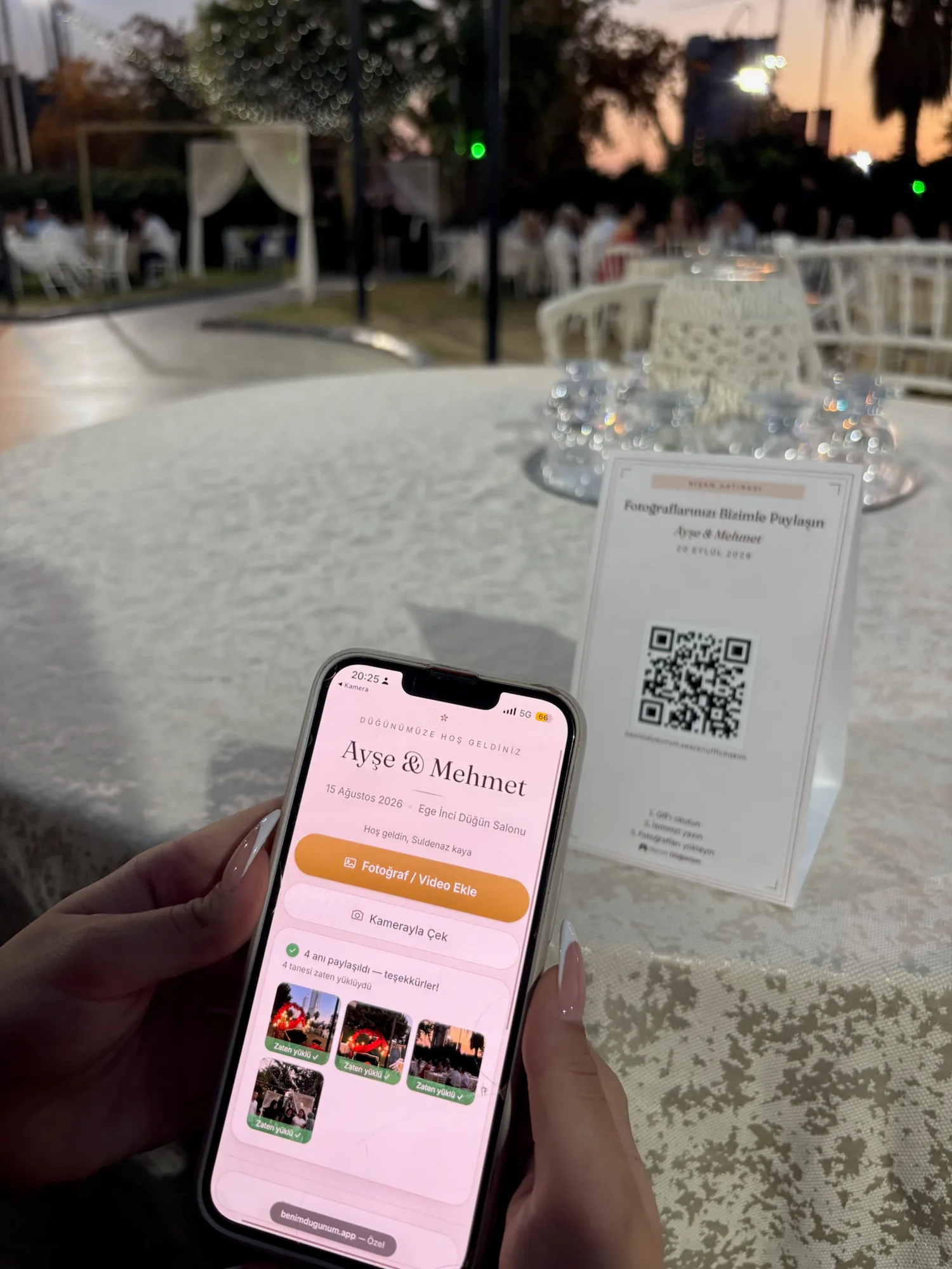 Bir misafirin düğün masasındaki QR kartını kullanarak fotoğraf yüklemesi